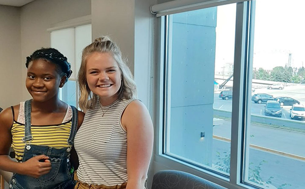 Two girls smiling at camera.